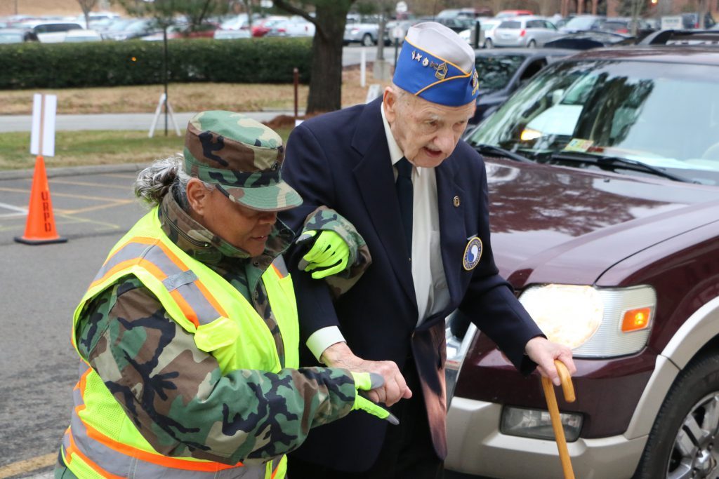 A members of the Virginia Defense Force assists a veteran at the Virginia World War I and World War II Commemoration Commission Tribute to Veterans Dec. 8, 2016, in Richmond, Virginia. (Photo by Cotton Puryear, Virginia National Guard Public Affairs)